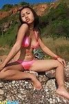 japonés modelo parpadea su los piqueros en Mini rosa bikini fuera de