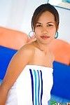 आबनूस थाई आकर्षक लिली कोह पहने मुश्किल से एक तौलिया और शर्मिला मुस्कान
