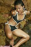 Elegante tailandés Brown cabello disrobes de su de ébano bikini en el mar costa