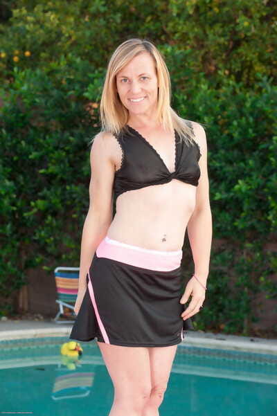Middle-aged broad Cody Hunter undresses by pool before teasing her pussy