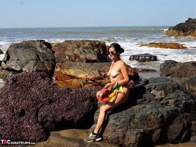 Mature amateur Diana Ananta is joined on the beach by her nudist friends