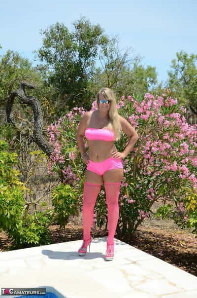Over 30 blonde Sweet Susi gets naked beside a pool in pink hosiery and shades