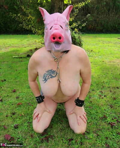 Busty amateur Mary Bitch sports a pigs head- clamps and a strapon on a lawn