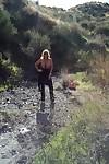 Mature blonde Sandra Otterson is walking topless outdoors so sexy
