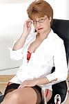Mature office lady in glasses posing barely clothed at her work place