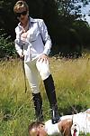 Fully clothed mature femdom in sunglasses abuses her male pet outdoor