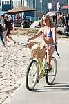 Older blonde babe Stevie Lix letting boobs free from bikini on beach