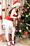 Brunette lady in pigtails striking sexy poses in Santa outfit and stockings