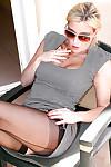 Fully clothed blonde in sunglasses and stockings having a smoke outdoors