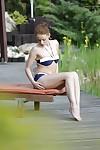 haut sur pattes rousse milf Sophie Lynx posant pour Candide bikini photos à l'extérieur