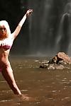 Blonde milf Jesse Jane is posing with naked boobies in front waterfall
