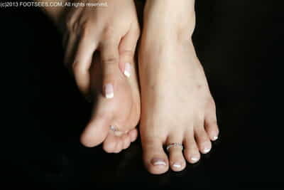 Caucasian female sports a pair of toe rings at the same time as showing her fascinating feet