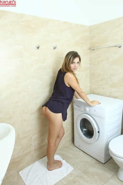 Young female shows off her undressed young snatch atop a washing machine