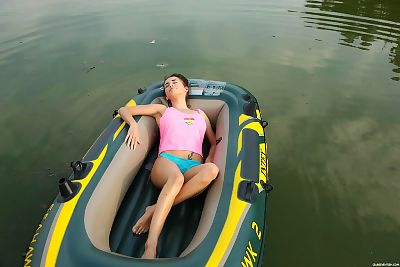 Europeu juvenil com um impecável corpo relaxa no um Miniatura Barco esfregando ela útero