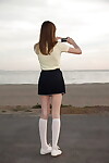 Diet brown hair young Audrey Star posing in a skimpy short skirt outdoors