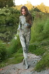 Nude young model with wish legs covers she is in mud from head to toes