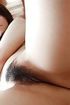 Asian teen Shiori Shimizu undressing and exposing her hairy pussy vulnerable the bed