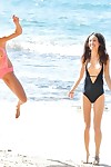2 lesbian hotties frolic in swimsuits at the beach in advance of strolling in the exposed
