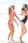 2 lesbian hotties frolic in swimsuits at the beach in advance of strolling in the exposed