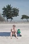 Boobsy سمراء الشعر يأخذ حمام شمس على العامة الشاطئ