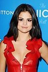Selena Gomez montrant pokies et le clivage dans rouge cuir