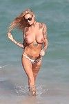 Jemma lucy shows off her vast entered milk cans at a beach