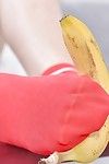 Leggy lass Ariana Ebony squashing banana with barefeet later on socks removal