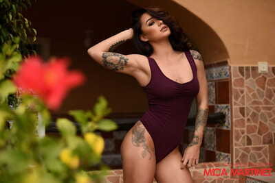 Hot dark brown Mica Martinez works her tattooed figure free of a bodysuit