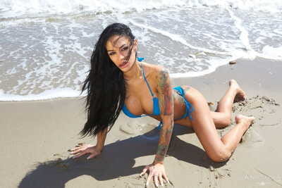 Hot tattooed MILF pornstar flaunts her lovely big tits in bikini on the sand