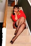 Danica on the stairs in short tartan petticoat and fishnet stockings