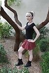 Tattooed fairy girl Symone posing non in nature\'s garb outdoors in pleated skirt
