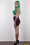 Tattooed girl with green hair and pierced tit pointers stands naked after disrobing