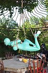BDSM fetish model Latex Lucy suspended by ropes in latex outfit outdoors