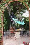 BDSM fetish model Latex Lucy suspended by ropes in latex outfit outdoors
