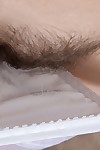 Emanuelle undresses and masturbates on her sofa